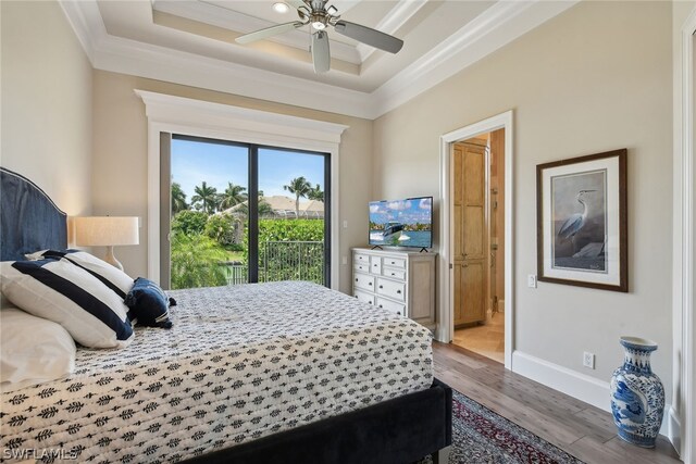 bedroom with light hardwood / wood-style flooring, ceiling fan, a tray ceiling, and access to exterior