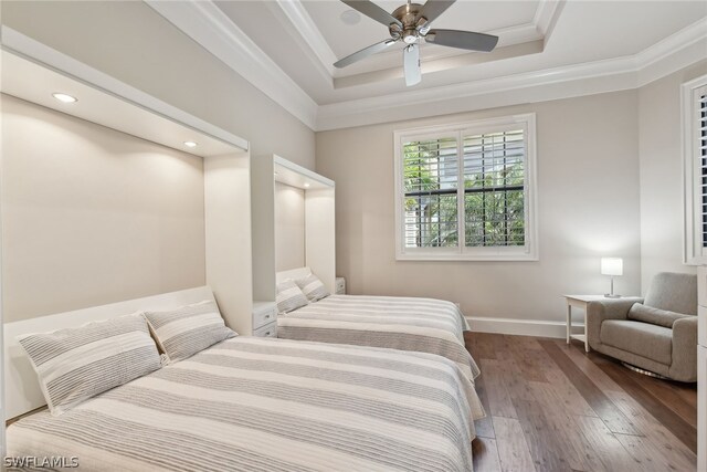 bedroom featuring ceiling fan, dark hardwood / wood-style floors, a raised ceiling, and ornamental molding