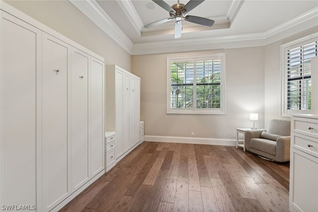 unfurnished room with crown molding, dark hardwood / wood-style flooring, ceiling fan, and a tray ceiling