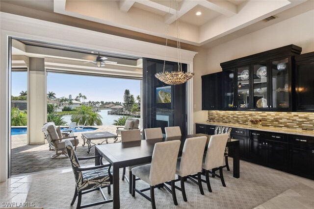 dining room featuring light tile flooring, coffered ceiling, plenty of natural light, and ceiling fan with notable chandelier