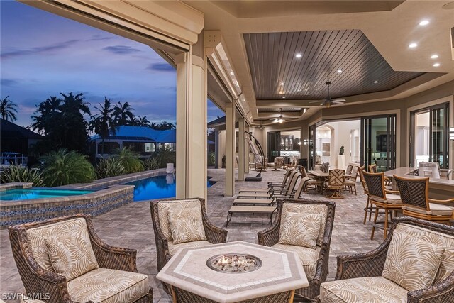 patio terrace at dusk with ceiling fan and outdoor lounge area