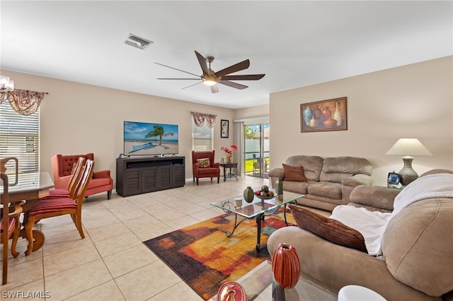 tiled living room featuring ceiling fan with notable chandelier