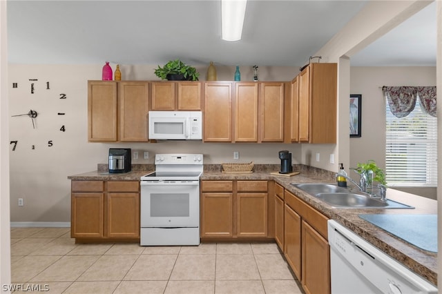 kitchen featuring sink, white appliances, and light tile floors