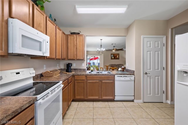 kitchen with hanging light fixtures, white appliances, ceiling fan with notable chandelier, sink, and light tile floors