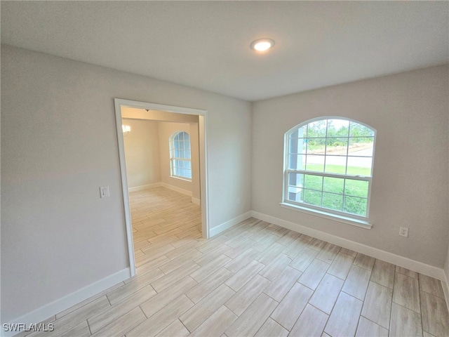 empty room with baseboards and light wood finished floors