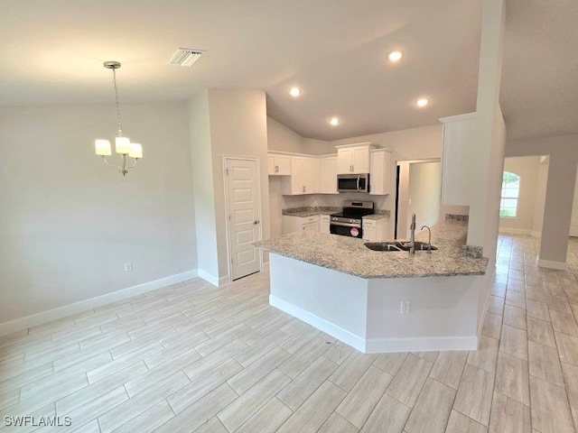 kitchen with light stone countertops, a peninsula, white cabinets, stainless steel appliances, and a sink