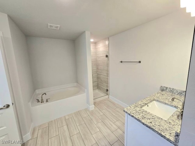 full bathroom with baseboards, visible vents, wood tiled floor, a shower stall, and a garden tub