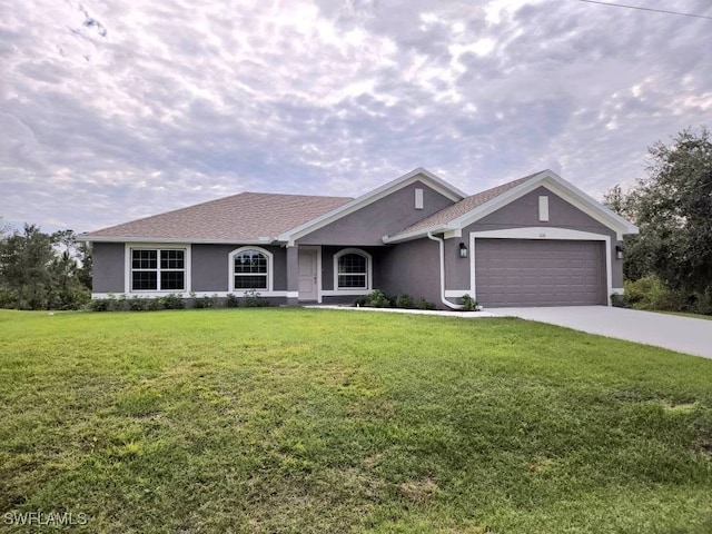 ranch-style home featuring a front yard, an attached garage, concrete driveway, and stucco siding