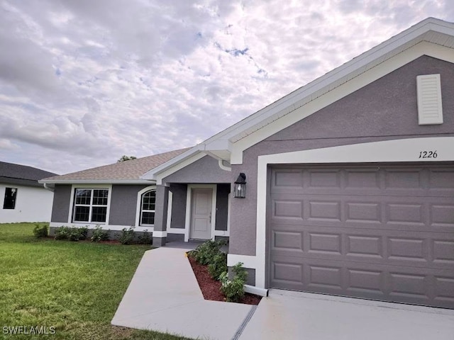 single story home with a garage, stucco siding, and a front lawn