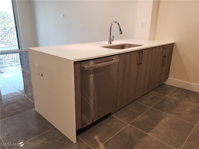 kitchen featuring dishwasher, dark tile patterned floors, and sink