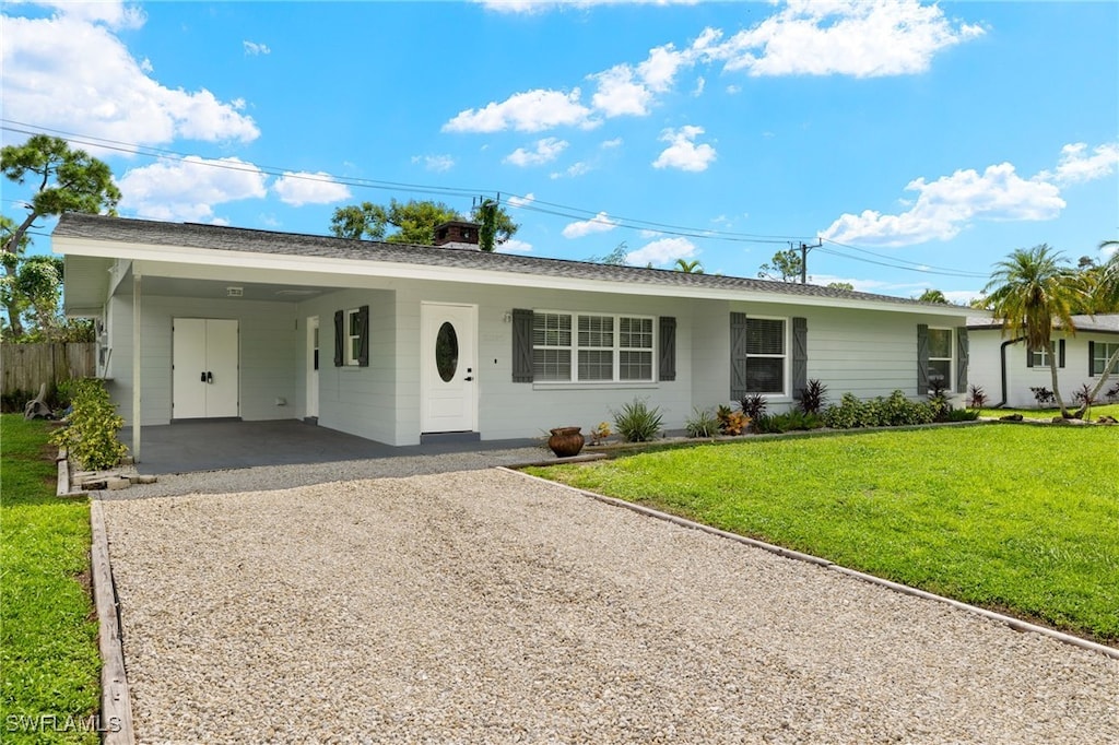 ranch-style home featuring a carport and a front yard