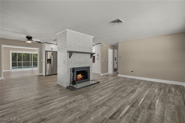 unfurnished living room featuring ceiling fan, hardwood / wood-style flooring, and a fireplace