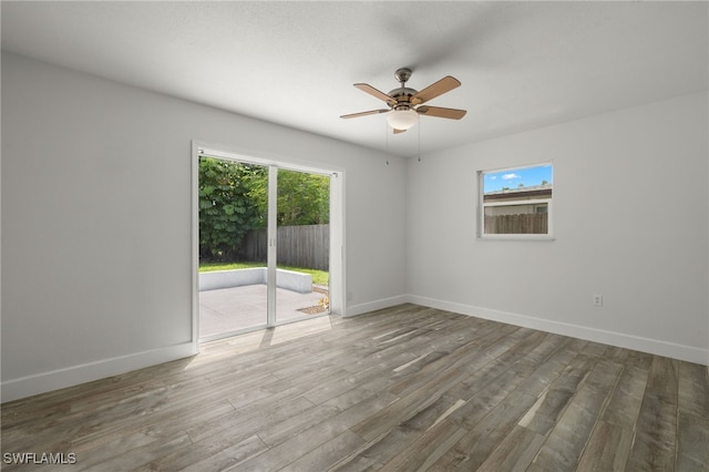 unfurnished room with plenty of natural light, hardwood / wood-style floors, and ceiling fan