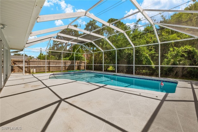 view of swimming pool featuring a patio area and glass enclosure