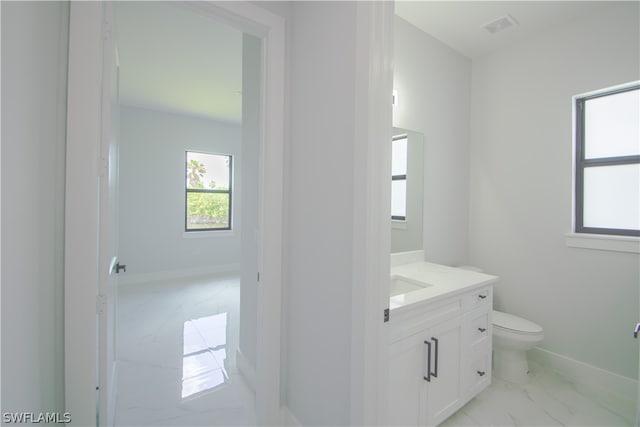 bathroom with tile flooring, vanity, and toilet