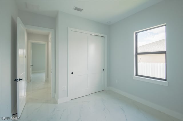 unfurnished bedroom featuring tile floors and a closet