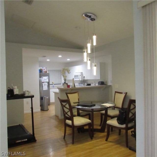 dining room featuring sink and light wood-type flooring