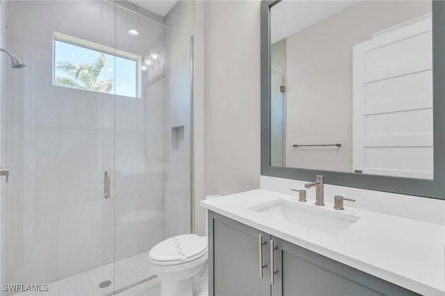 full bathroom featuring a stall shower, vanity, and toilet