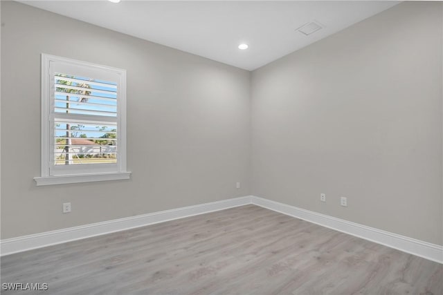 unfurnished room with recessed lighting, wood finished floors, and baseboards