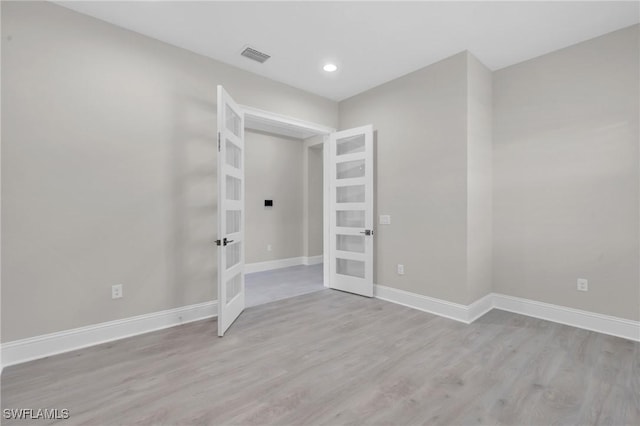 unfurnished room with visible vents, baseboards, wood finished floors, french doors, and recessed lighting