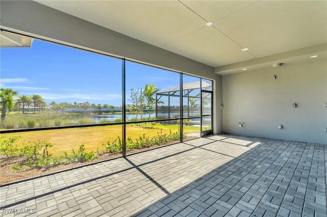 unfurnished sunroom featuring a water view