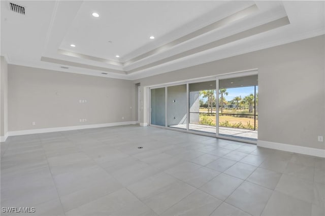 empty room featuring baseboards, a tray ceiling, and recessed lighting