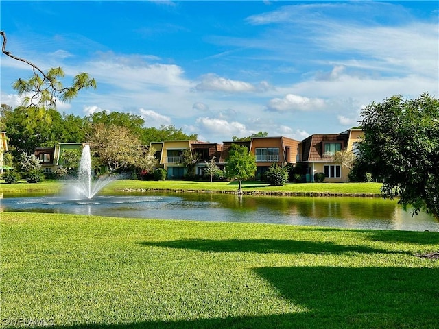 view of community with a yard and a water view