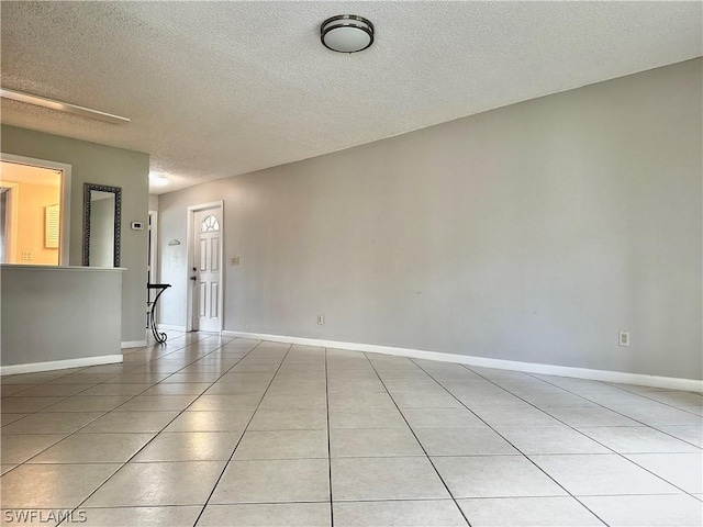 tiled spare room with a textured ceiling