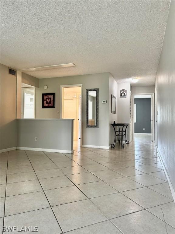 unfurnished room featuring light tile patterned flooring and a textured ceiling