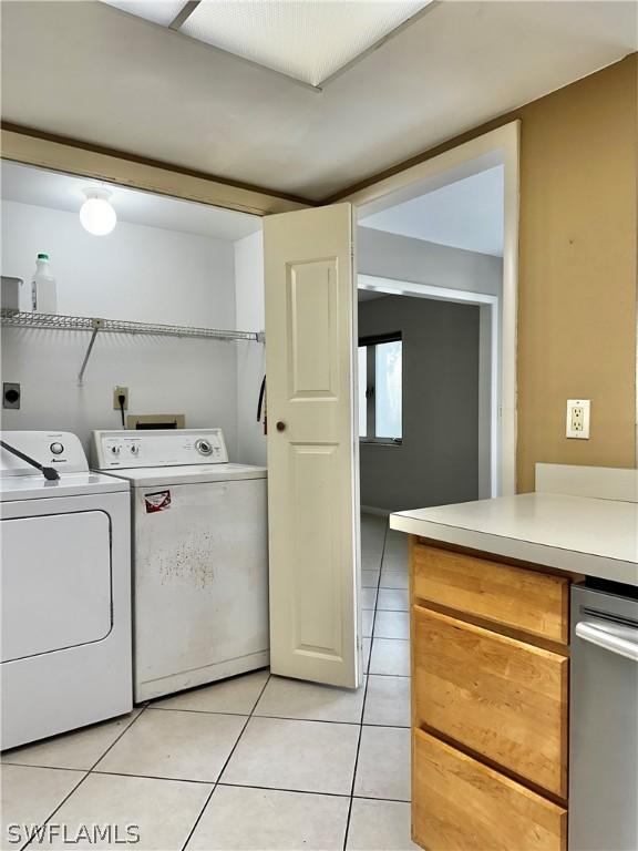 laundry area with light tile patterned floors and washing machine and clothes dryer