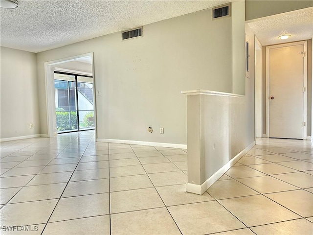 unfurnished room featuring light tile patterned floors and a textured ceiling