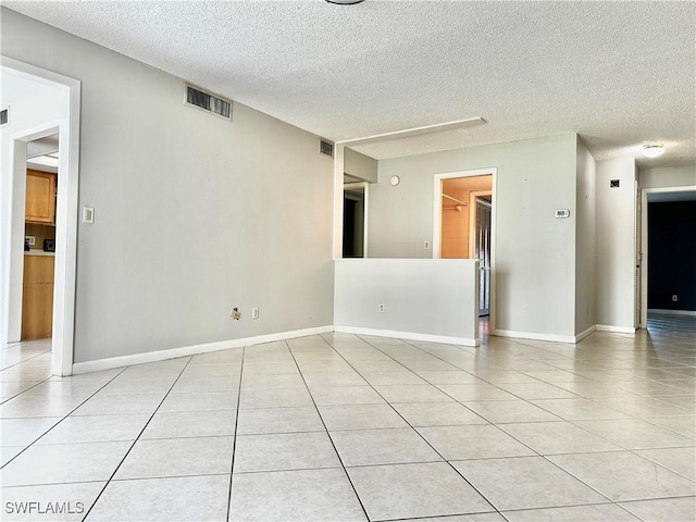 unfurnished room featuring light tile patterned floors and a textured ceiling