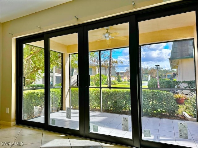 doorway to outside with ceiling fan and light tile patterned flooring