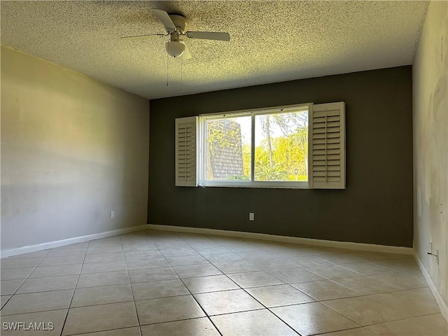 unfurnished room with light tile patterned floors, baseboards, a textured ceiling, and ceiling fan