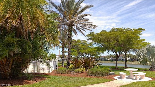 view of home's community featuring a water view and a lawn