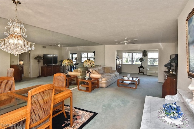 living room with carpet flooring, a textured ceiling, ceiling fan with notable chandelier, and lofted ceiling