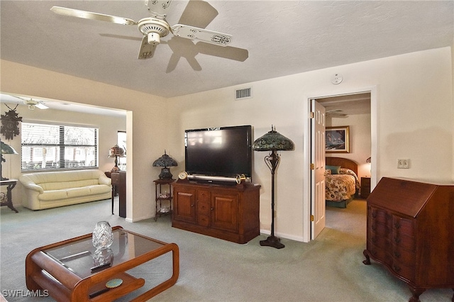 carpeted living room with ceiling fan