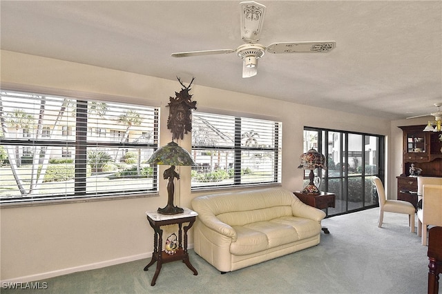 carpeted living room with ceiling fan