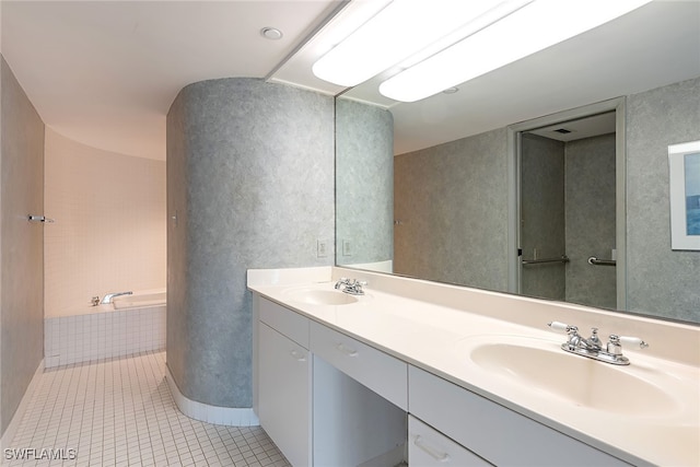 bathroom with vanity, tile patterned floors, and tiled tub