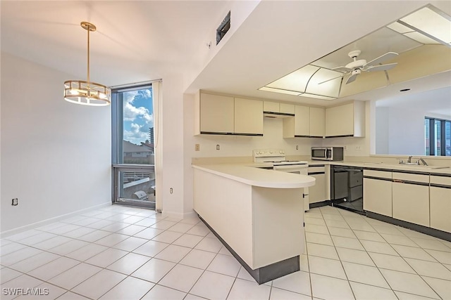 kitchen featuring a peninsula, black dishwasher, light countertops, stainless steel microwave, and pendant lighting