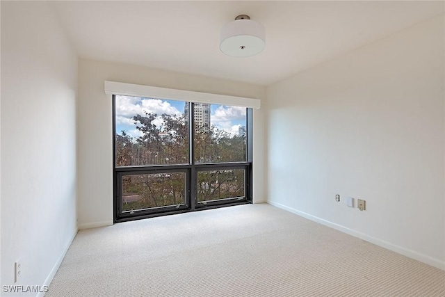 spare room featuring carpet flooring and baseboards