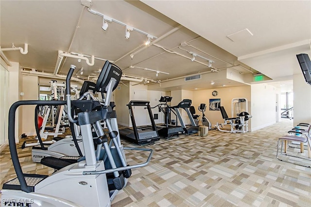 exercise room featuring track lighting, visible vents, and carpet flooring