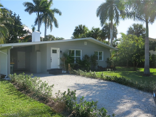 ranch-style house with a carport and a front lawn