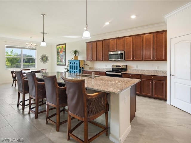 kitchen featuring pendant lighting, a kitchen island with sink, sink, a notable chandelier, and appliances with stainless steel finishes