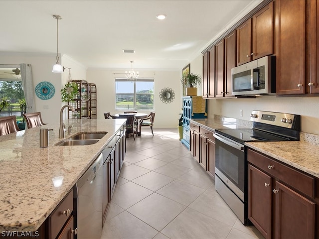 kitchen featuring appliances with stainless steel finishes, hanging light fixtures, sink, and a chandelier