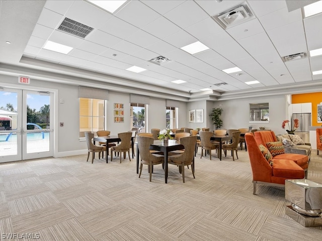 dining space with french doors, light carpet, and a wealth of natural light