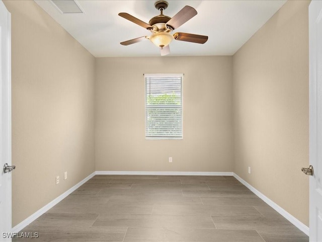 unfurnished room featuring baseboards, visible vents, ceiling fan, and wood finished floors