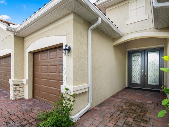 property entrance featuring a garage and french doors