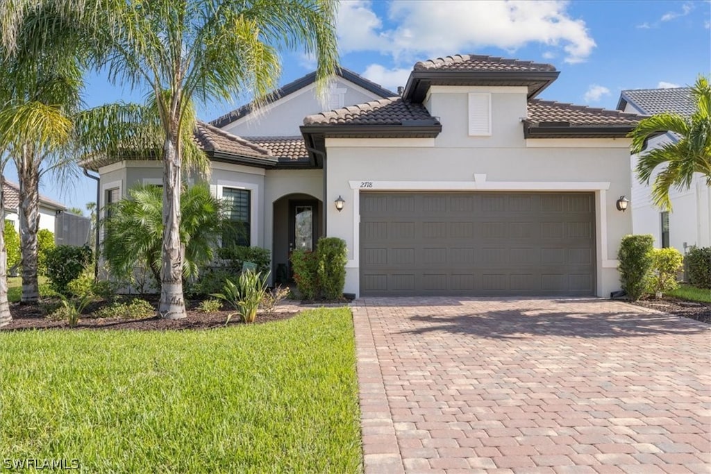 mediterranean / spanish house featuring a front lawn and a garage