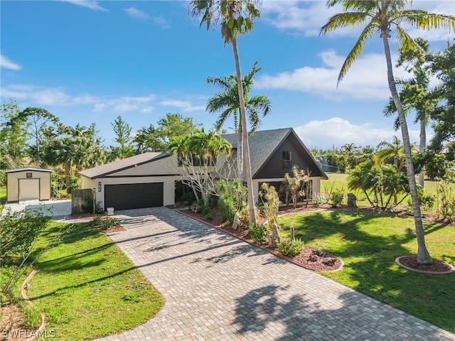 view of front of property featuring a front yard and a garage